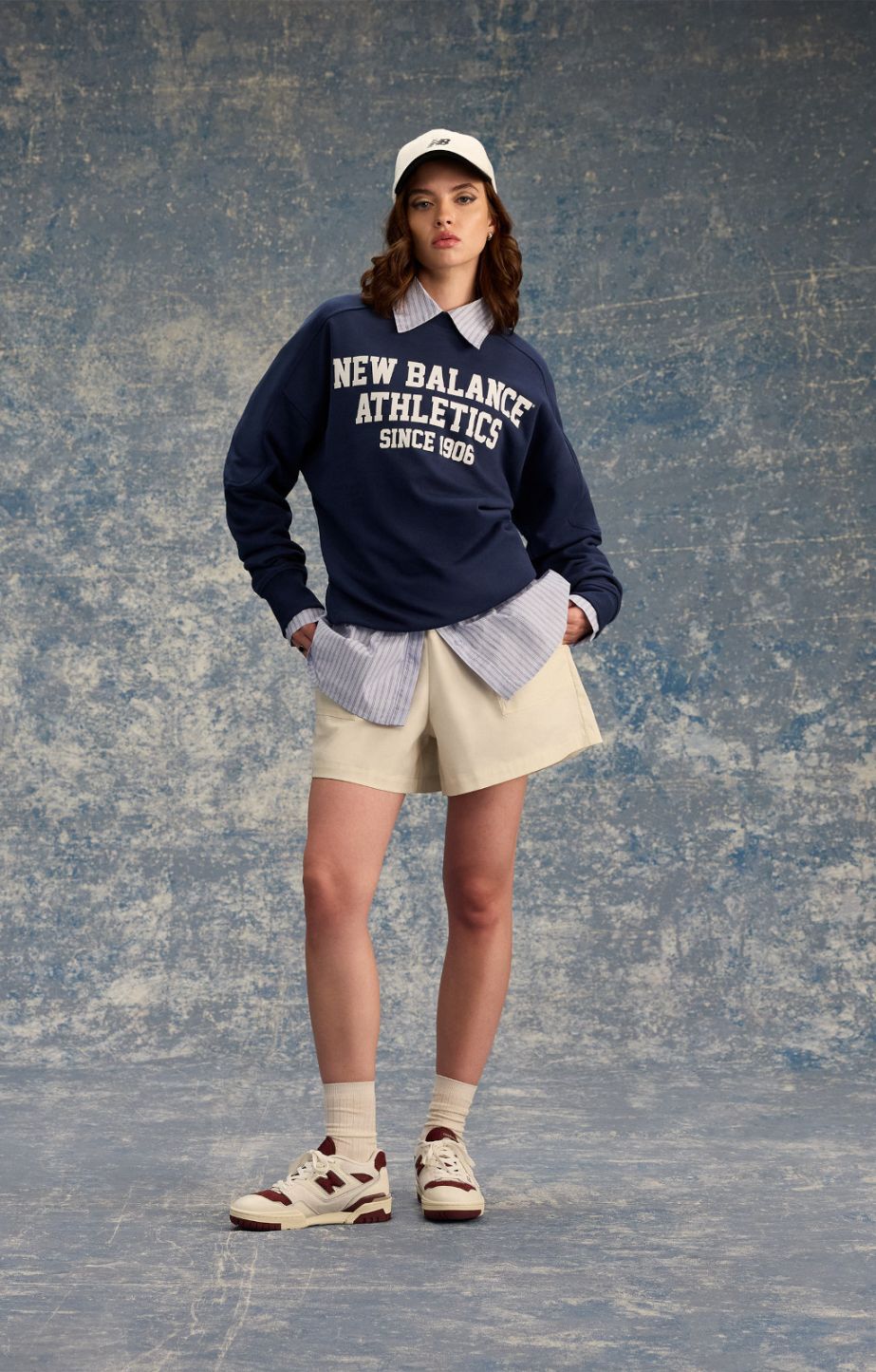 Woman standing in a studio, wearing new balance apparel and new balance 550 sneakers