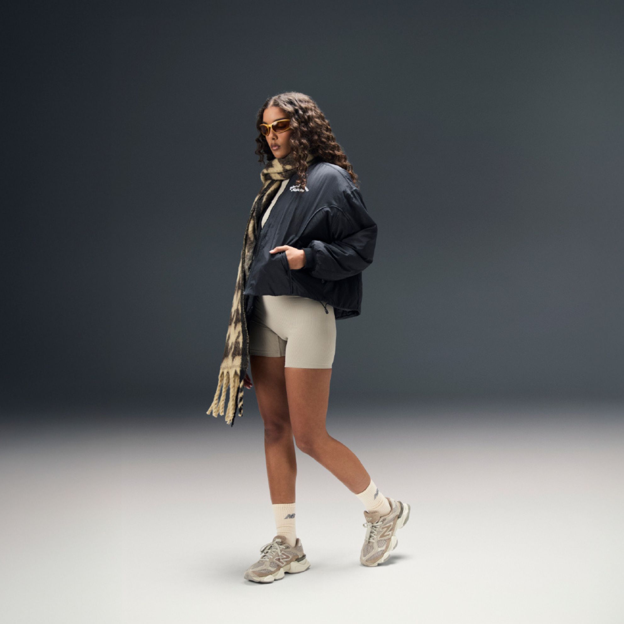 Woman posing in a studio background wearing 9060 sneakers