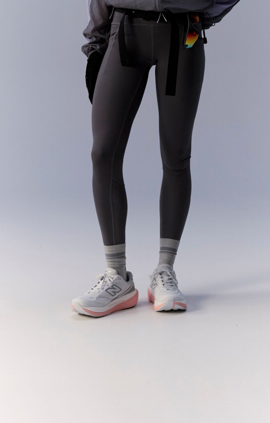 Waist down image of woman wearing white, pink and grey 1080v15 running shoes 