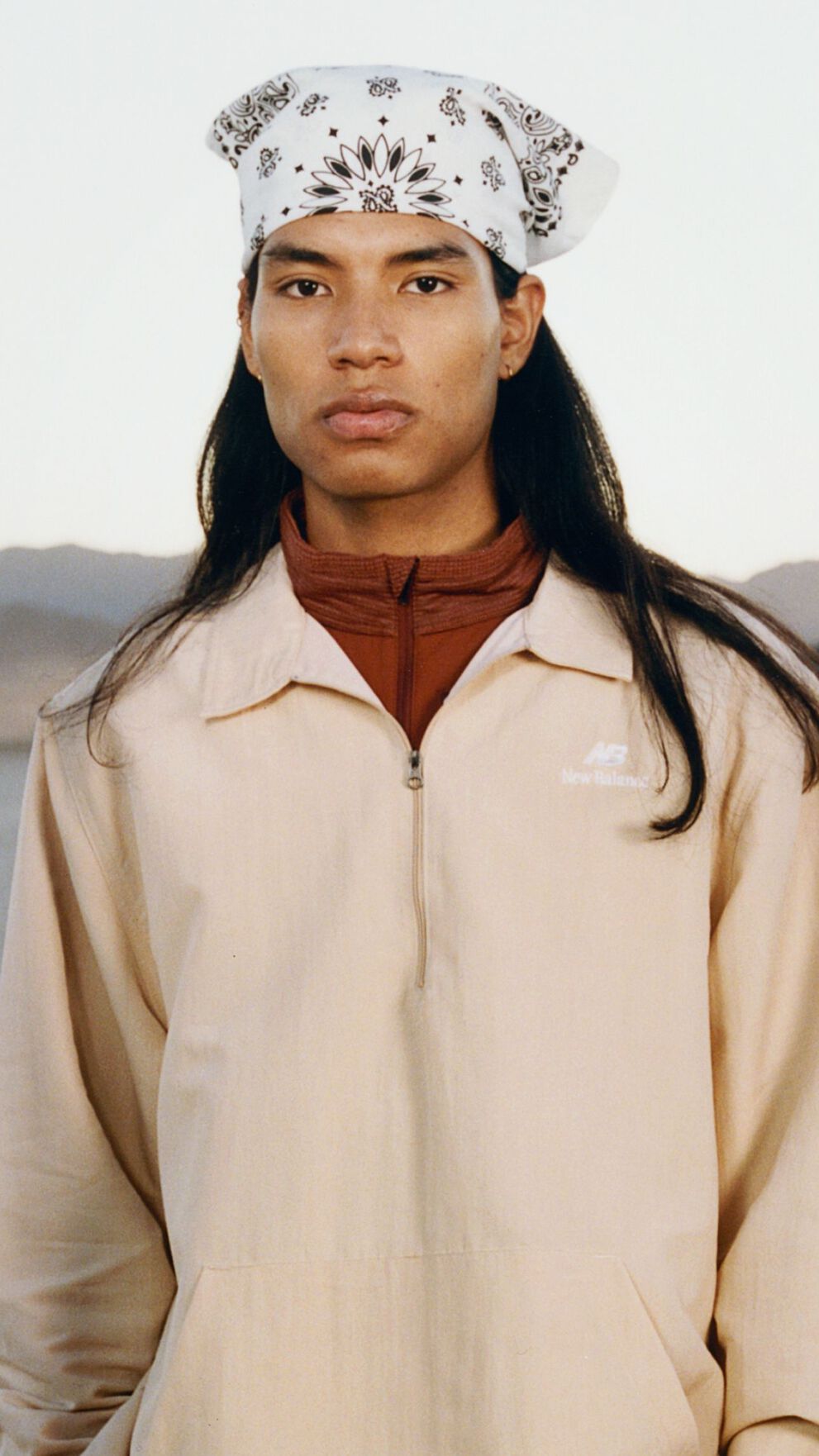 A man standing in a desert environment. 