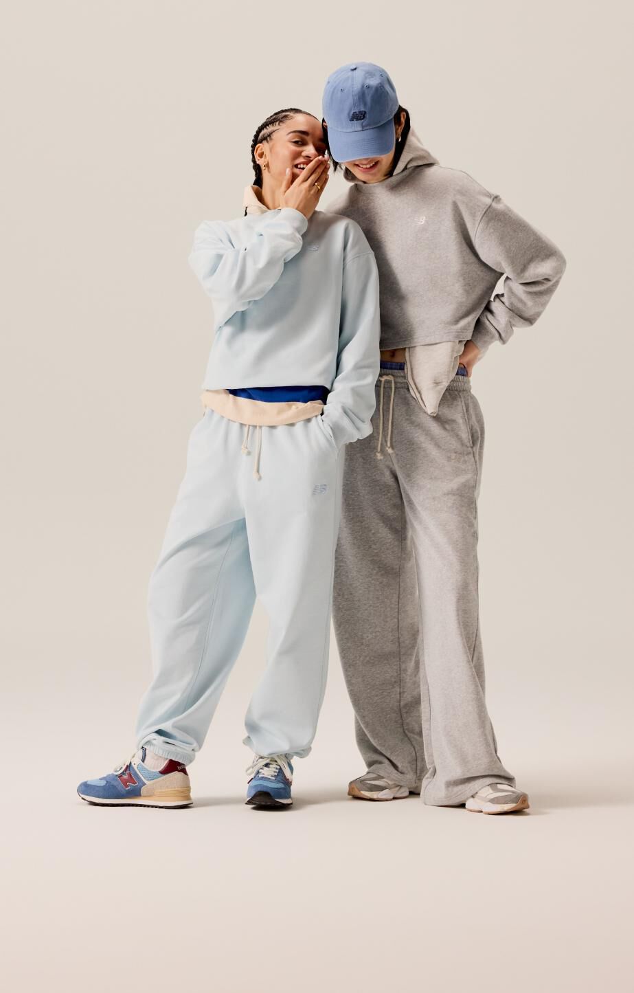 A couple wearing light blue and grey sweats while talking to each other. 