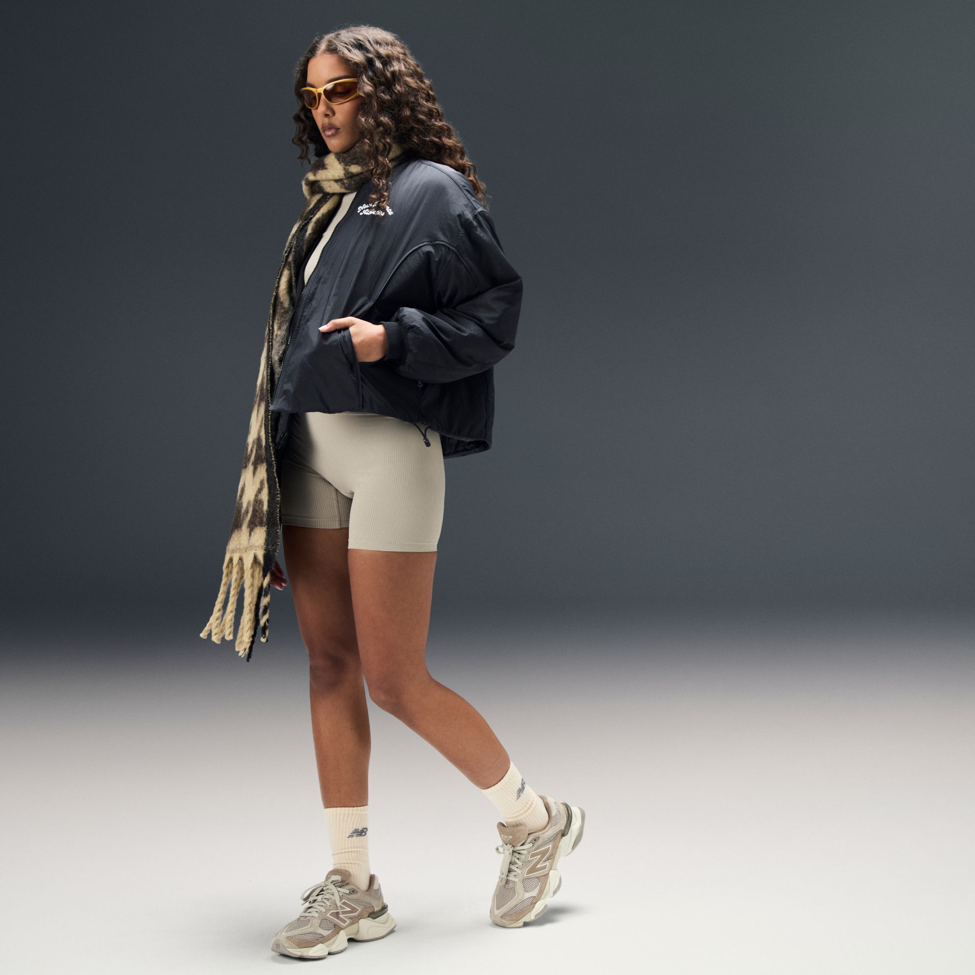 Woman posing in a studio background wearing 9060 sneakers