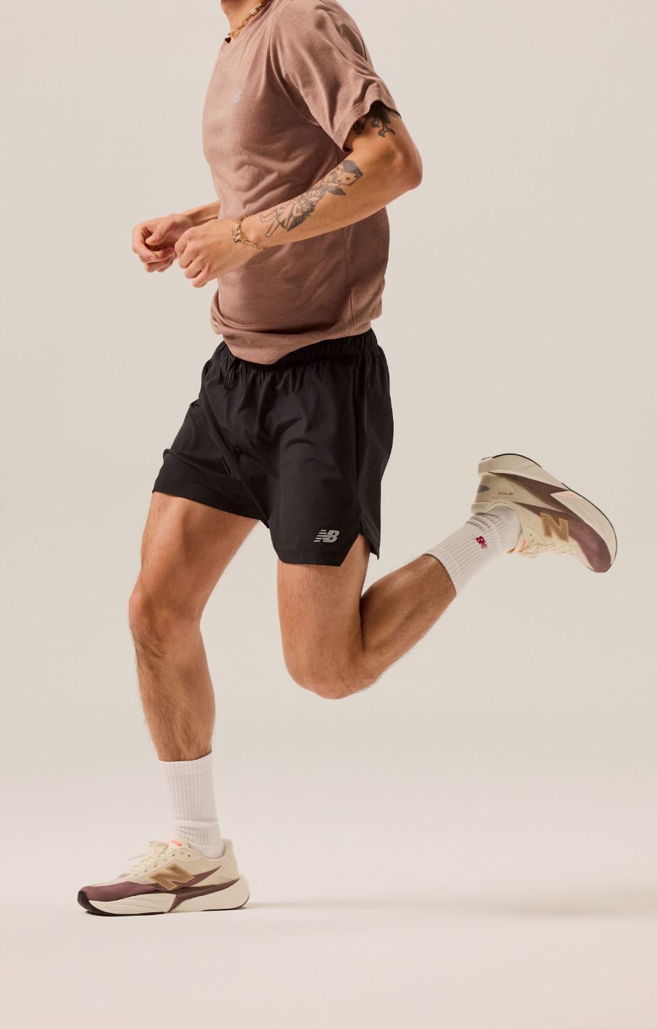 man running in a studio, wearing new balance fuelcell rebel v5