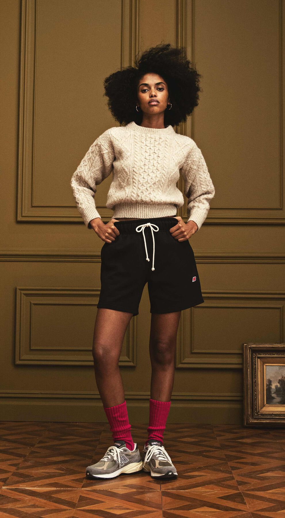 Woman standing in a beautiful indoor environment wearing apparel and footwear from the SS ‘22 MADE in USA Collection.