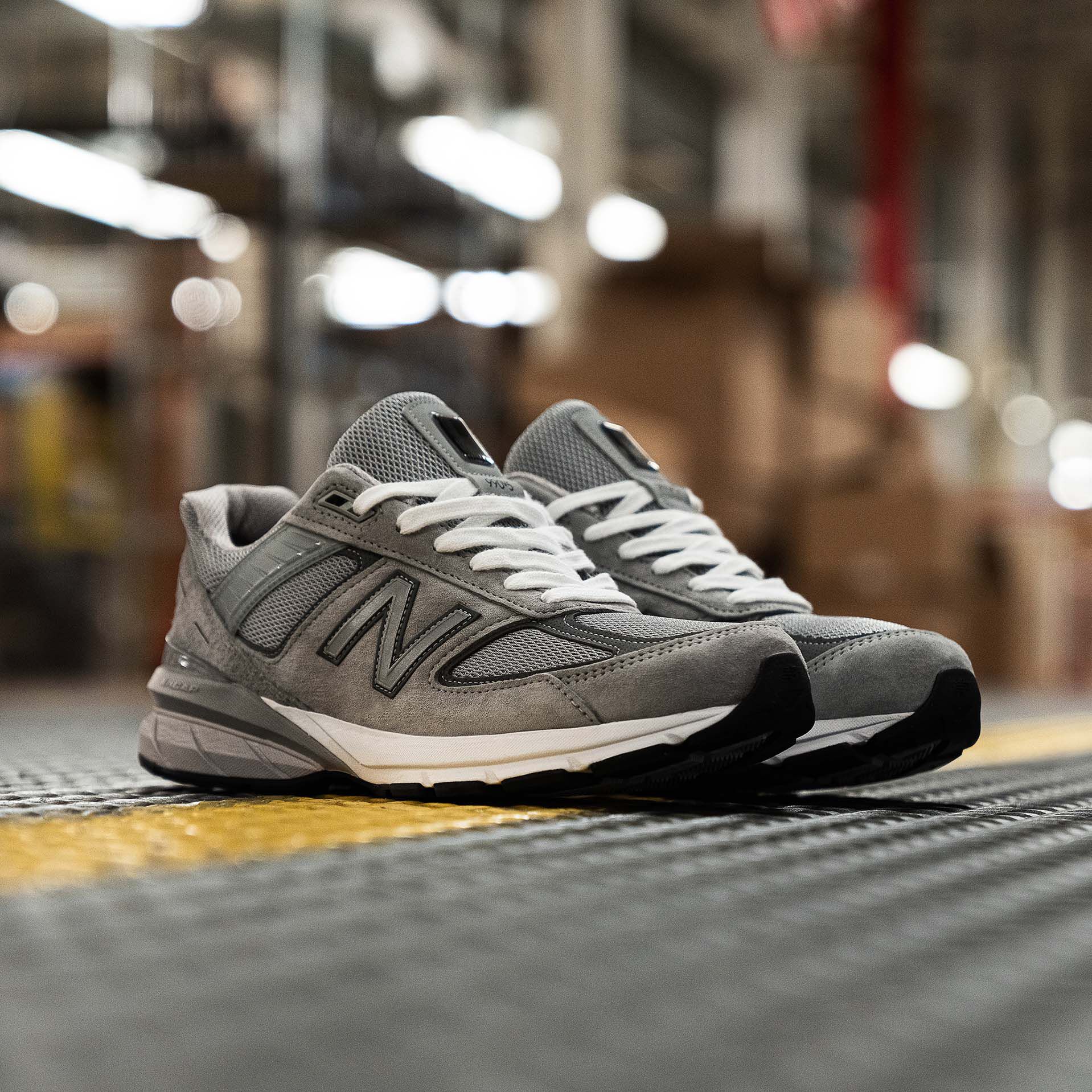 Pair of grey 990v5 MADE in USA shoes sitting on factory floor