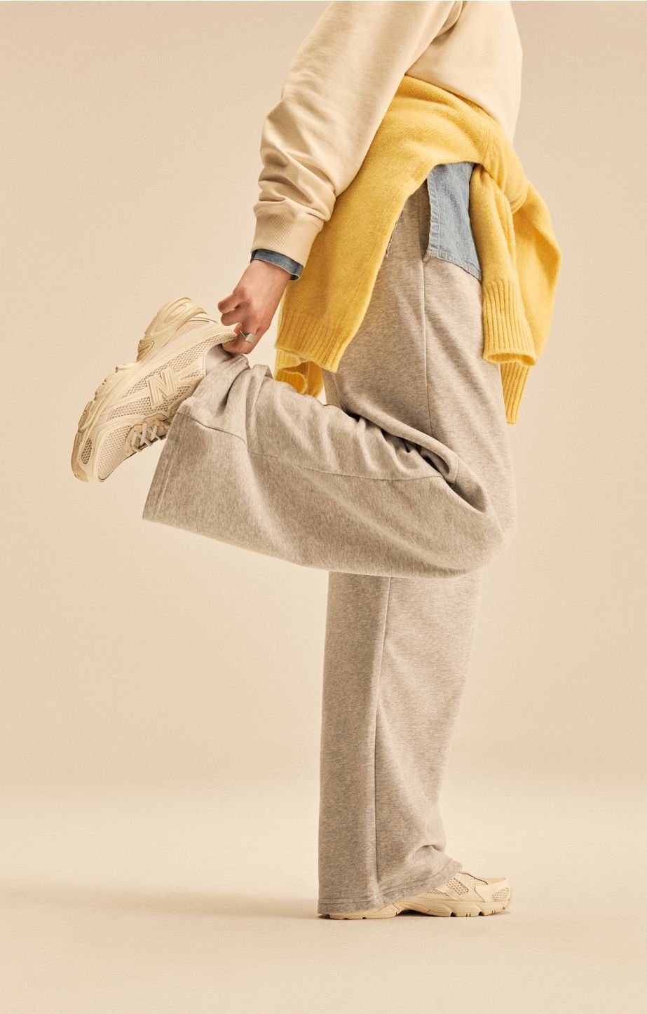 A person standing against a tan studio backdrop. 